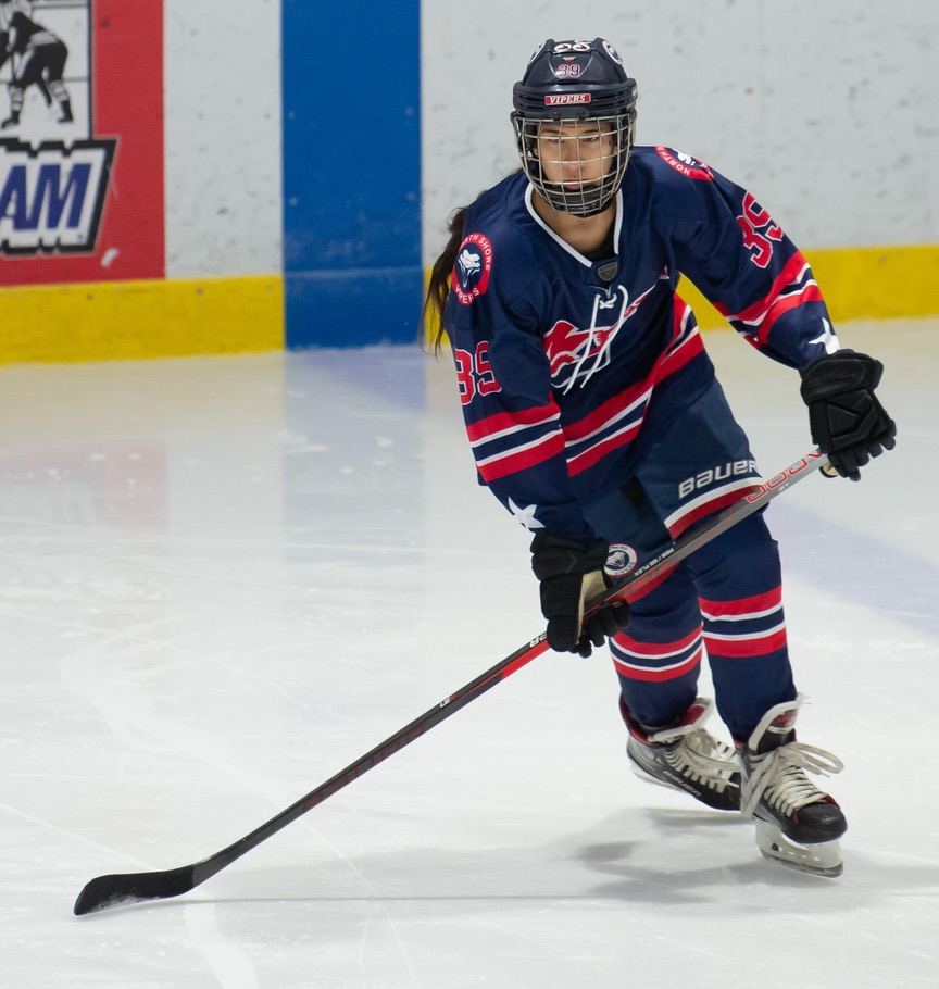 High school hockey player skating with the puck